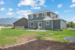 Rear view of house with a patio, a mountain view, board and batten siding, and a shingled roof