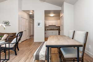 Dining room featuring light wood-style floors and vaulted ceiling
