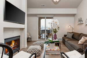 Living area with wood finished floors and a tile fireplace