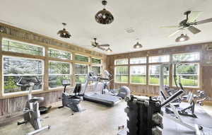 Workout area featuring wood walls, ceiling fan, and a textured ceiling