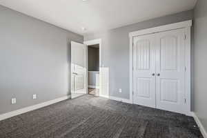 Unfurnished bedroom with carpet flooring and a closet
