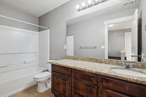 Full bath featuring light tile patterned flooring, vanity, and bathing tub / shower combination