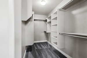 Walk in closet with dark carpet