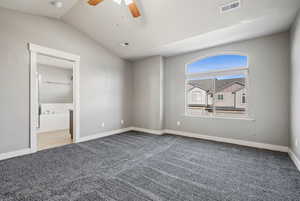 Unfurnished bedroom featuring light colored carpet, lofted ceiling, ceiling fan, and ensuite bathroom