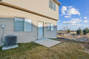 View of exterior entry featuring a patio and a lawn