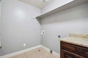 Washroom with light tile patterned floors, hookup for an electric dryer, and hookup for a washing machine