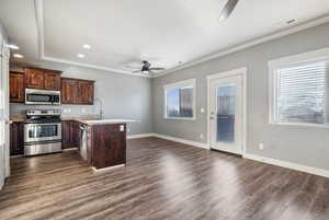 Kitchen featuring ceiling fan, a peninsula, stainless steel appliances, crown molding, and dark brown cabinetry