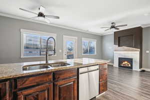 Kitchen featuring ceiling fan, light stone counters, dishwasher, and crown molding