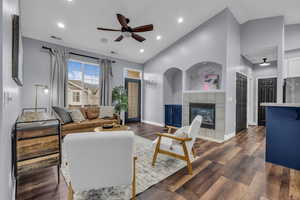 Living area featuring a ceiling fan, dark wood-style floors, a tile fireplace, recessed lighting, and high vaulted ceiling