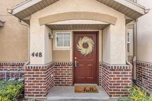 Doorway to property featuring stucco siding and brick siding