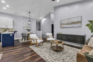 Living area with dark wood-style floors, recessed lighting, and lofted ceiling