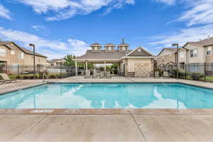 Community pool with a patio area and a residential view