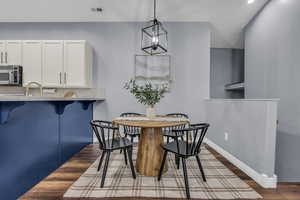 Dining space featuring dark wood-type flooring, a chandelier, and recessed lighting