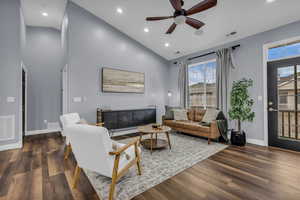 Living room with high vaulted ceiling, recessed lighting, a ceiling fan, and dark wood-style floors