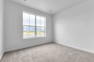 Unfurnished room with a mountain view and light carpet