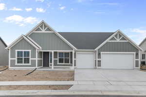 Craftsman-style house with a porch, board and batten siding, a garage, and concrete driveway