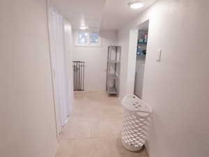Hallway featuring light tile patterned flooring and baseboards