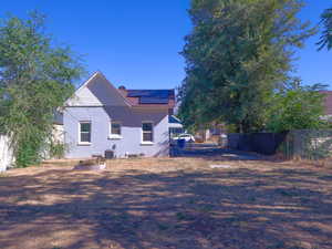 View of side of property with roof mounted solar panels and a chimney