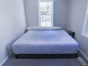 Bedroom featuring carpet floors and baseboards