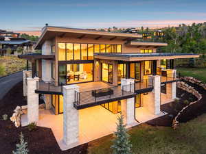 Back of property at dusk with a patio area