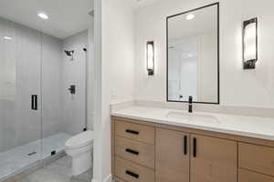 Full bathroom with vanity, a shower stall, and recessed lighting
