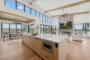 Kitchen with light brown cabinetry, light stone countertops, modern cabinets, light wood finished floors, and recessed lighting