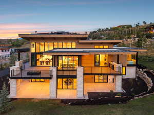 Back of house at dusk featuring a patio, a standing seam roof, and a metal roof