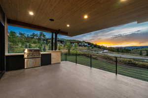Patio terrace at dusk featuring exterior kitchen, a patio area, and a mountain view
