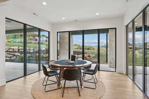 Dining space with light wood-style floors and recessed lighting