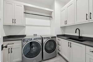 Washroom with washer and clothes dryer and cabinet space