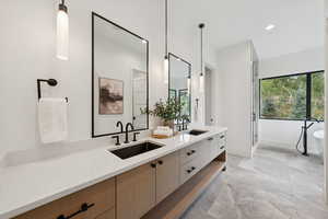 Full bath featuring double vanity, a freestanding bath, a shower stall, and recessed lighting