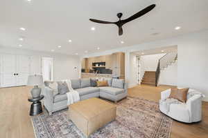 Living area with light wood finished floors, recessed lighting, stairs, and a ceiling fan