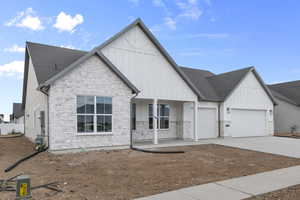 Modern farmhouse with board and batten siding, covered porch, and stone siding