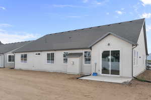 Rear view of property featuring roof with shingles, a patio, and stucco siding