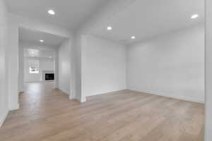 Spare room featuring recessed lighting, a fireplace, and light wood-type flooring