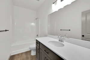 Bathroom with  shower combination, vanity, and dark wood-type flooring