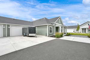 View of front of home featuring roof with shingles, concrete driveway, and board and batten siding