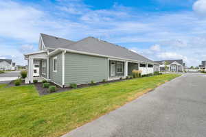 View of property exterior with roof with shingles and a lawn