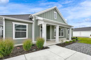 View of front of property featuring board and batten siding, covered porch, and roof with shingles