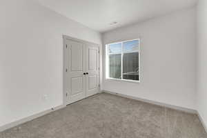 Unfurnished bedroom with carpet and a closet