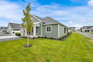 View of front of house with board and batten siding, a front lawn, a residential view, and a shingled roof