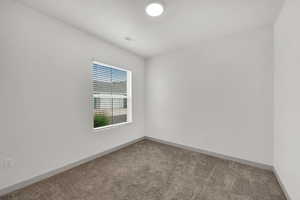 Carpeted spare room with baseboards