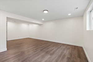 Below grade area featuring dark wood-style floors and recessed lighting