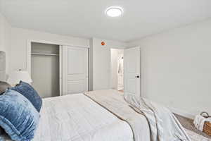 Carpeted bedroom featuring a closet and baseboards