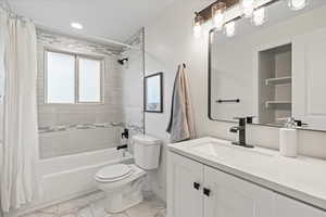 Full bathroom featuring shower / bathtub combination with curtain, vanity, light marble finish flooring, and recessed lighting