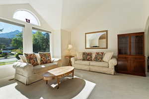 Living area featuring carpet flooring and high vaulted ceiling