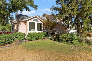 View of front of house with stucco siding and a front yard
