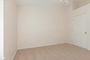 Empty room with light carpet and baseboards