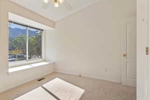 Spare room featuring carpet flooring, ceiling fan, and a mountain view