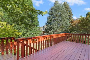 Wooden deck with view of wooded area